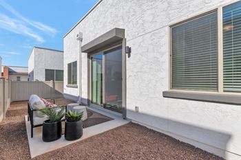 A white house with a patio and a chair.